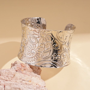 Close-up of silver-tone wide open cuff bracelet with intricate paisley floral embossing