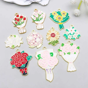 Flat lay of diverse floral enamel charms for DIY jewelry making with vivid flower designs