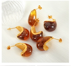 Detailed macro shot of vintage amber resin earrings with polished 18K gold plating