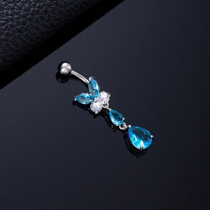 Macro shot of butterfly belly button ring with blue teardrop zircon and silver metal finish