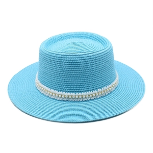 Close-up of sky blue boater hat featuring elegant white lace and pearl embellishments