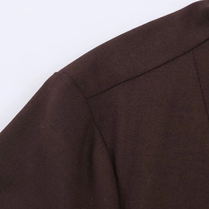 Macro view of shoulder stitching and high-density dark brown knit fabric texture
