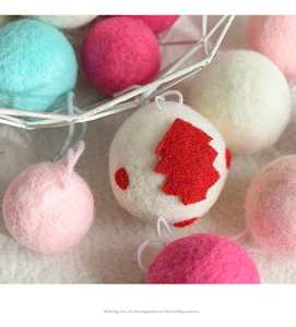 Macro shot of red and white wool felt Christmas balls with festive holiday greeting text