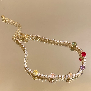 Elegant gold plated tennis bracelet featuring colorful zircon stones on a mirrored surface