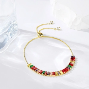 Detail of adjustable gold slider bracelet featuring rainbow baguette-cut cubic zirconia