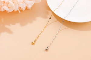 Close-up of gold and silver titanium heart necklace chains with lobster clasps