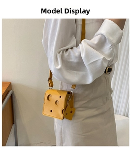 Detail view of yellow cheese-shaped mini crossbody bag with hollow design and cute charm