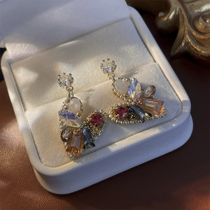 Detail of luxury heart earrings with multicolor crystals in a vintage velvet jewelry box