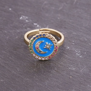 Macro shot of gold adjustable ring featuring blue enamel star moon and colorful crystals
