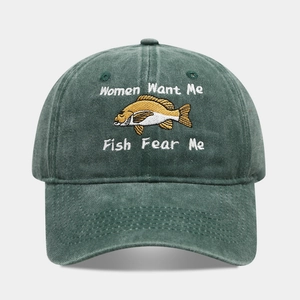 Detail of fish embroidery and humor text on washed dark green cotton baseball cap