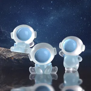 Set of three luminous astronaut resin figurines for desktop decor in starry background