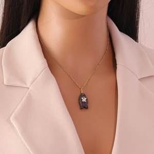 Elegante goldene Fisch-Halskette mit lila Naturstein am Modell im rosa Blazer