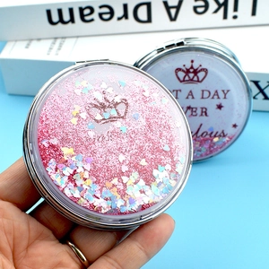 Gros plan du miroir de maquillage rose à sable mouvant avec paillettes en cœur et métal