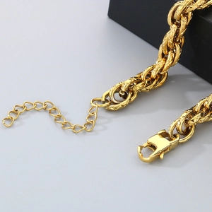 Détail du gros bracelet en titane doré montrant le fermoir mousqueton et la chaînette