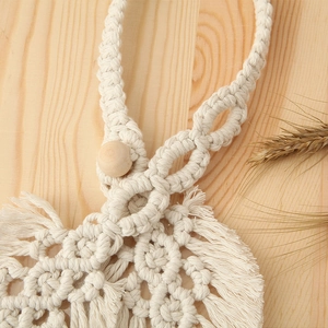 Close-up of macrame cotton rope weave with wooden bead detail and elegant fringe tassels