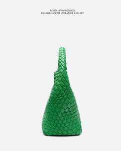 Detail of green hand-woven leather tote bag with unique texture and integrated handle