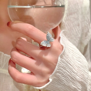 Close-up of a model wearing the gradient blue butterfly ring with crystal accents