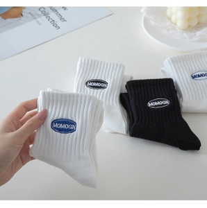Close-up of white cotton ribbed crew socks with blue embroidered logo on the cuff
