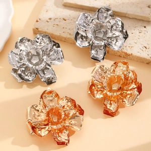 Close-up of matte layered flower earrings in silver and gold with hammer textured petals