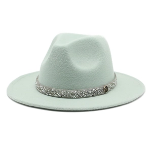 Detail of mint green wool felt fedora featuring rhinestone band and golden M emblem