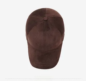 Top view of dark brown corduroy baseball cap showing textured fabric and metal side badge
