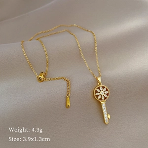 Gold starburst key pendant necklace with crystals on stainless steel chain