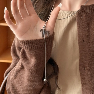 Close-up of a silver snake chain necklace featuring a brown pony pendant and slider bead