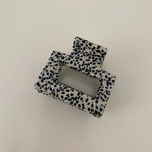 Detail of square hollow hair claw clip with black and white spotted dalmatian pattern