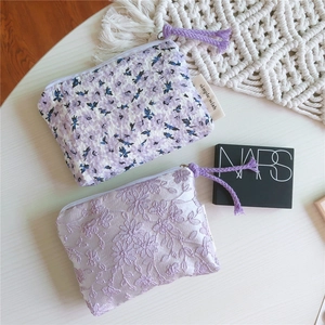 Détail de porte-monnaie violet crème en seersucker floral et broderie de dentelle