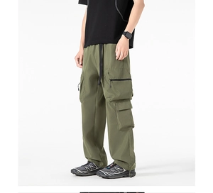 Dettaglio dei pantaloni cargo verde militare con ampie tasche laterali e vestibilità ampia