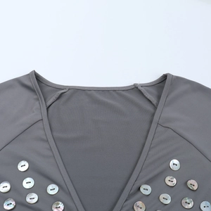 Détail d'une robe grise à col en V avec boutons nacrés et texture en maille lisse