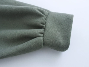 Macro view of grey wool coat cuff detail showing premium fabric texture and stitching
