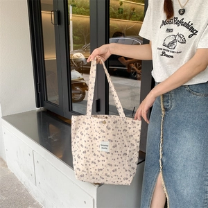 Detail of floral canvas tote bag showing the Sozakka studio label and metal snap closure