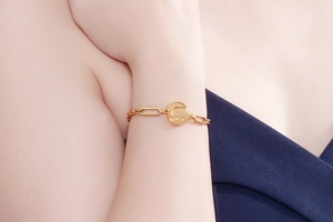 Close-up of elegant gold bracelet featuring an elephant pendant on a paperclip chain