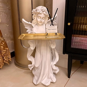 White angel sculpture floor ornament holding a gold tray with a glass aromatherapy bottle