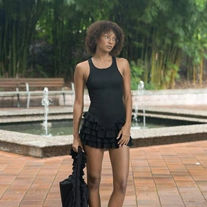 Détails des volants superposés sur la robe noire sans manches avec tissu texturé