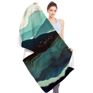Microfiber beach towel with blue mountain landscape and gold birds held by a model