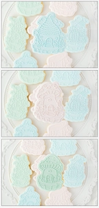 Detail of mushroom house embossing on pastel blue and pink forest theme fondant cookies