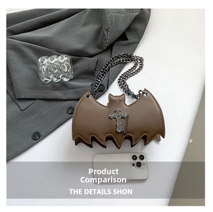 Detail view of brown bat-shaped bag with vintage metal cross pendant and chain strap