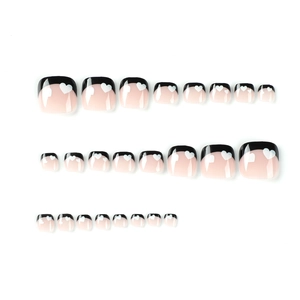 Black French tip press-on toenails with white heart patterns on 24 piece set