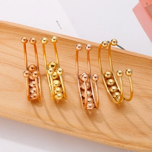 Detail of sliding gold and rose gold metal beads on U-shaped titanium steel ear cuffs
