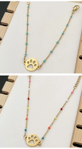 Detail of colorful beads and gold paw print pendant on minimalist bohemian bracelets