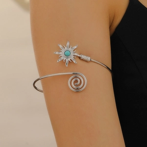 Detailed view of silver arm cuff with turquoise stone and sunflower engraving