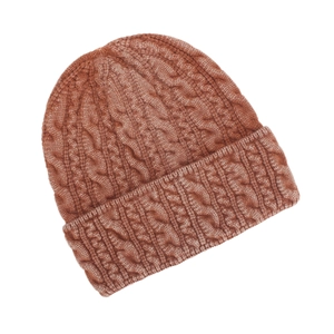 Detailed view of rust-red cable knit beanie showing thick texture and folded cuff