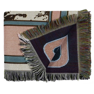 Detail view of woven bohemian picnic blanket showing texture and fringe tassels