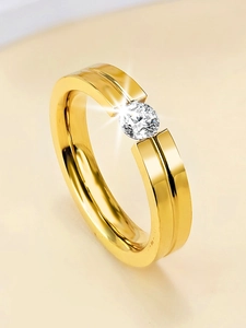 Macro detail of gold-plated titanium ring featuring a tension-set round diamond stone