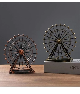 Detail of vintage iron ferris wheel models in bronze and copper finish on wooden desk