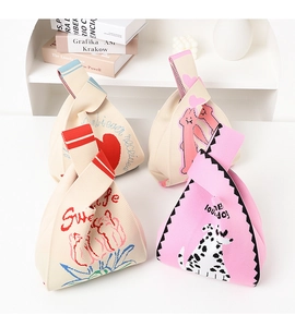 Close-up of knit wrist bag with rabbit and floral patterns in beige and pink colors
