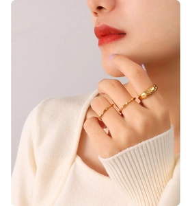 Detailed view of three stackable 18K gold-plated rings with zircon stars and textures