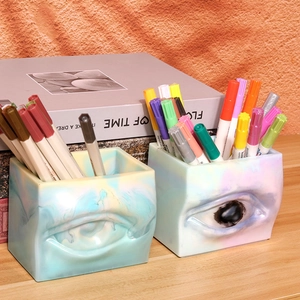 Detailansicht der Augen-Stiftehalter aus Kunstharz mit Marmortextur und Stiftaufbewahrung